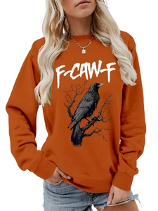 Dettaglio felpa arancione con stampa corvo e grafica artistica F-CAW-F su tessuto