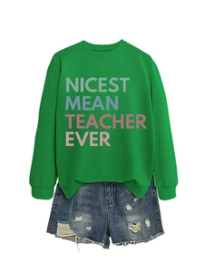 Flat lay of green 'Nicest Mean Teacher Ever' sweatshirt and ripped denim shorts set