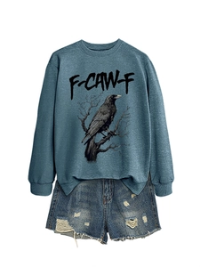 Posa piatta di una felpa blu navy con stampa aquila e pantaloncini di jeans usurati su bianco