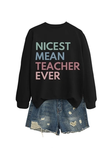 Detail of Nicest Mean Teacher Ever sweatshirt paired with distressed denim shorts