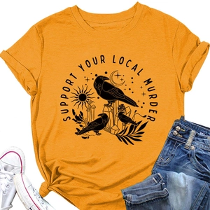 Dettaglio della t-shirt senape con grafica gotica di corvi e motivi celestiali