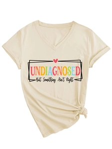 Détail du T-shirt en coton beige à col en V avec texte 'UNDIAGNOSED' et petit cœur rouge