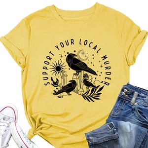 Dettaglio maglietta giallo zenzero con stampa corvo occulto e jeans blu denim