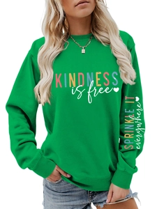 Détail du sweat vert avec slogan Kindness is free et imprimé sur la manche