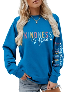 Détail du sweat bleu montrant l'imprimé kindness is free et le texte sur la manche