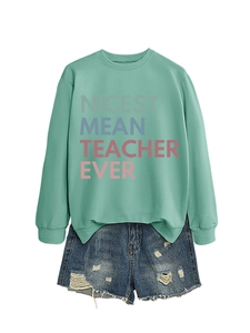 Detail of mint green sweatshirt with Nicest Mean Teacher Ever print and denim shorts