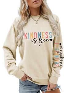 Détail du texte Kindness is Free et imprimé sur manche de sweat crème