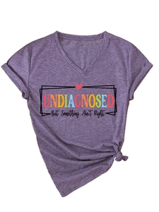 Détail d'un t-shirt violet à col en V avec imprimé undiagnosed et nœud sur le devant
