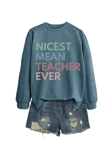 Detail of teal sweatshirt with 'NICEST MEAN TEACHER EVER' text and ripped denim shorts