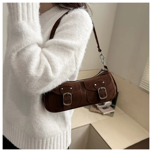 Dettaglio della borsa baguette in pelle scamosciata marrone con fibbie e catena in metallo