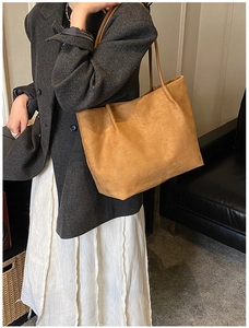 Dettaglio della borsa tote in pelle scamosciata marrone con texture naturale e tracolla