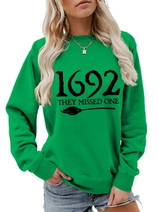 Detail of green witch sweatshirt featuring 1692 they missed one text and broom print
