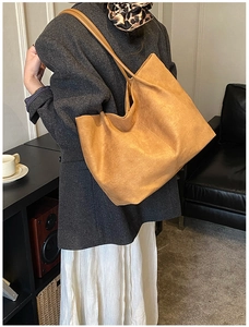 Borsa tote marrone opaca indossata a spalla in un ambiente di vita quotidiana retrò