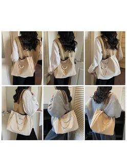 Detail of beige tote bag with pearl chain straps showing shoulder carry on model