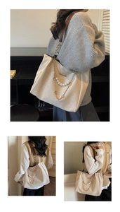Detail of off-white tote bag featuring a gold chain with white pearl pendant decoration