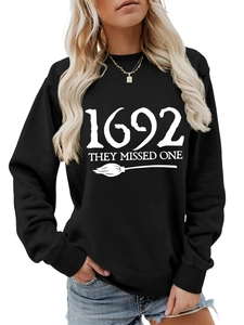 Detailed view of the 1692 They Missed One graphic on a black crewneck sweatshirt