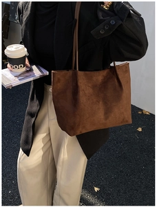 Dettaglio della borsa tote in pelle scamosciata marrone scuro con texture opaca