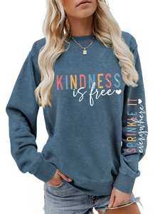 Détail du sweat bleu montrant l'imprimé Kindness is Free et le texte sur la manche