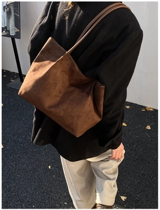 Detailed view of large brown suede tote bag showing soft texture and shoulder strap fit