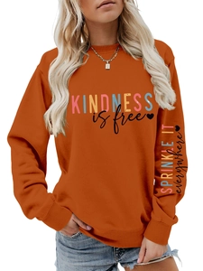 Détail d'un sweat orange avec lettrage Kindness et motif imprimé sur la manche