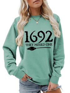 Detail of mint green sweatshirt with 1692 they missed one text and broom print