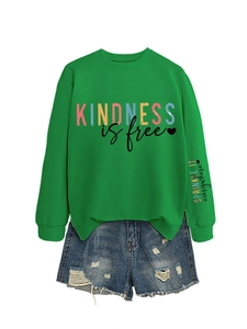 Vue détaillée du sweat vert Kindness Is Free avec manche imprimée et short en jean