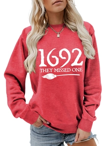Close-up of red cotton sweatshirt featuring 1692 They Missed One white graphic print