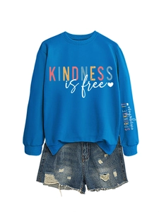 Détail du sweat bleu Kindness Is Free avec impression sur manche et short en jean usé
