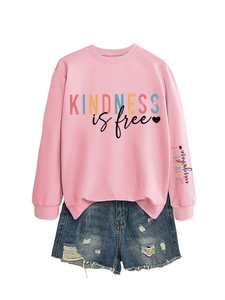 Détail du sweat rose imprimé Kindness is free et short en jean avec bords effilochés