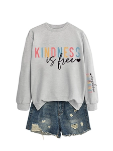Détail du sweat gris imprimé kindness is free et du short en jean bleu délavé