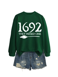 Flat lay of dark green 1692 Salem sweatshirt with blue distressed denim shorts