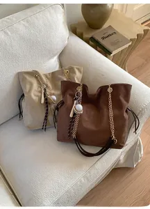 Suede tote bags with chain straps and baseball charms in khaki and brown colors