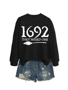Detail of 1692 They Missed One print on a casual black sweatshirt and denim shorts
