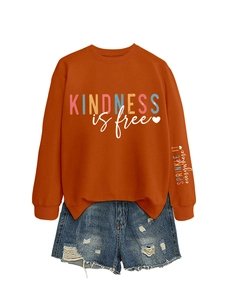 Gros plan sur l'imprimé kindness is free sur sweat orange avec détails sur les manches