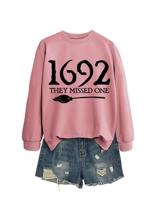 Pink sweatshirt featuring black 1692 THEY MISSED ONE lettering and broom graphic detail