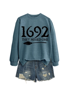 Detail view of 1692 They Missed One print on a casual blue-grey crewneck sweatshirt