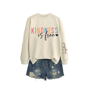 Sweat crème Kindness is free avec short en jean bleu délavé sur fond blanc épuré
