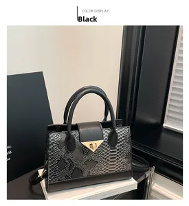 Close-up of black snakeskin pattern small tote bag with gold triangle twist lock