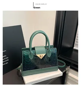Detail of green snake pattern faux leather handbag with gold V-shaped rotating lock