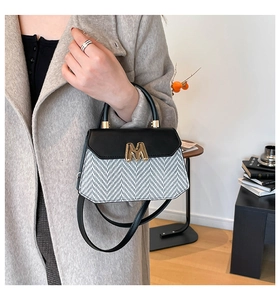 Fashionable woven crossbody bag with black leather flap and golden M detail