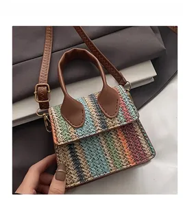 Close-up of bohemian mini woven bag with colorful stripes and brown leather handles