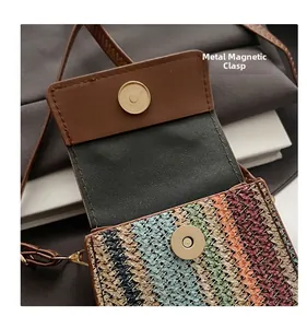 Detailed macro view of the gold magnetic snap closure on the colorful woven handbag