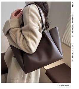 Side view of a large dark brown tote bag worn by a model for a commute style look