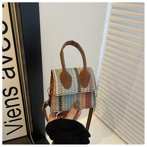 Detail of colorful woven wave pattern and brown PU leather handles on a mini tote bag