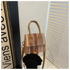 Detail of hand-woven texture and leather handle on a vintage style crossbody bag