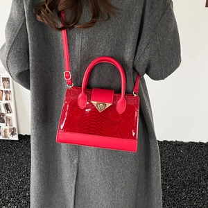 Red faux leather tote bag with snakeskin pattern and gold V-lock on grey wool coat background