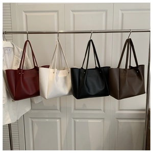 Detailed display of four large vintage leather tote bags in burgundy, cream, black, and brown