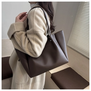 Brown soft leather tote bag detail showing large capacity and natural drape on shoulder