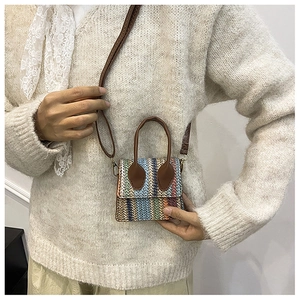 Detailed view of a mini bohemian woven crossbody bag with multicolor stripes and leather strap