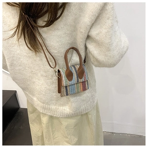 Detailed back view of a woman wearing a mini multicolored woven linen crossbody bag